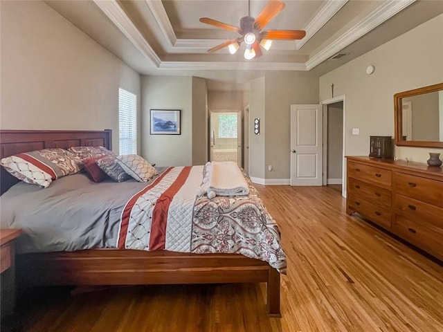 bedroom with ceiling fan, hardwood / wood-style flooring, ornamental molding, and a raised ceiling