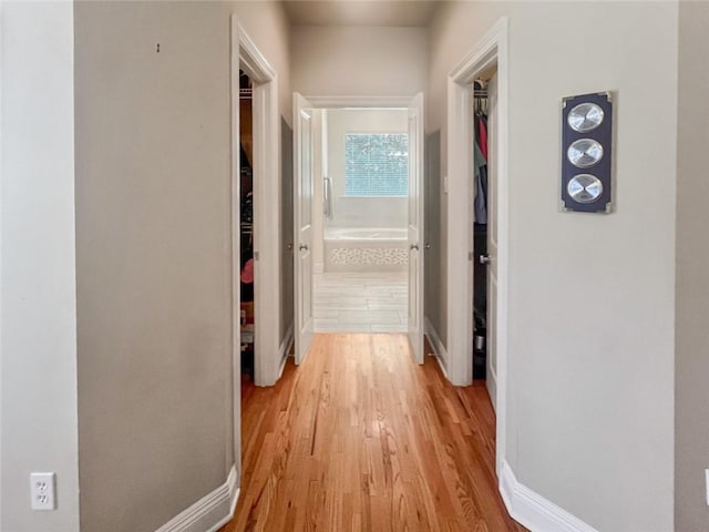 hallway with light hardwood / wood-style floors