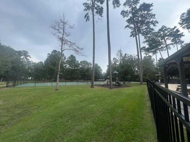 view of yard featuring tennis court and a playground