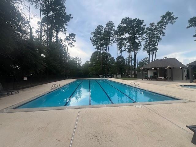 view of swimming pool featuring a community hot tub and a patio