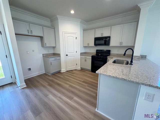 kitchen with light stone counters, sink, light hardwood / wood-style flooring, black appliances, and crown molding