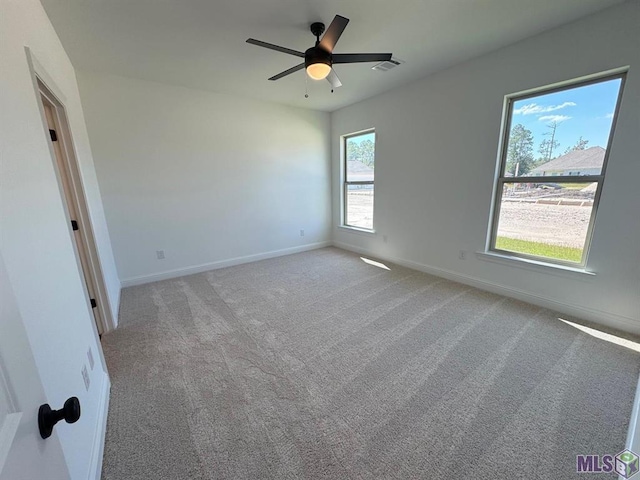 spare room with ceiling fan and light carpet