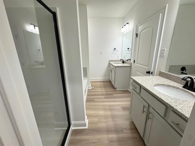 bathroom with an enclosed shower, hardwood / wood-style flooring, and vanity