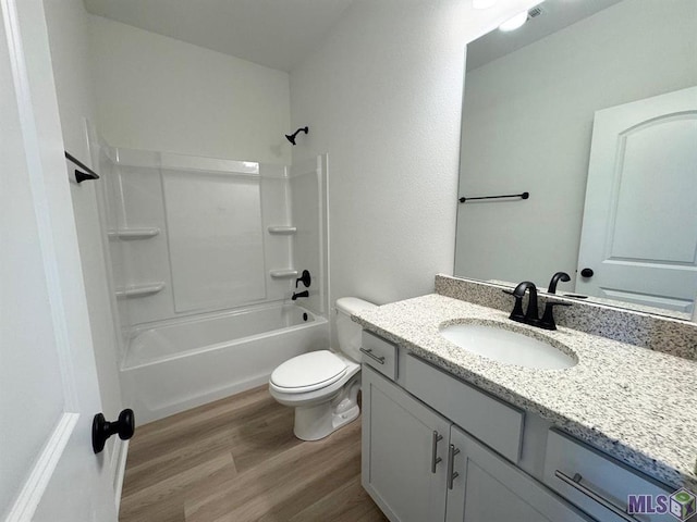 full bathroom featuring hardwood / wood-style floors, tub / shower combination, vanity, and toilet