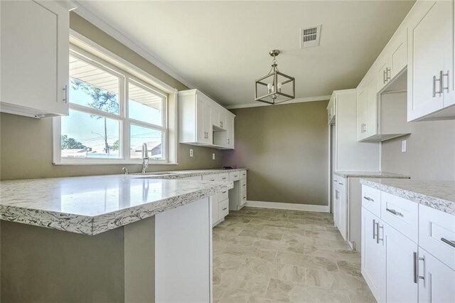 kitchen with sink, white cabinets, pendant lighting, and a chandelier