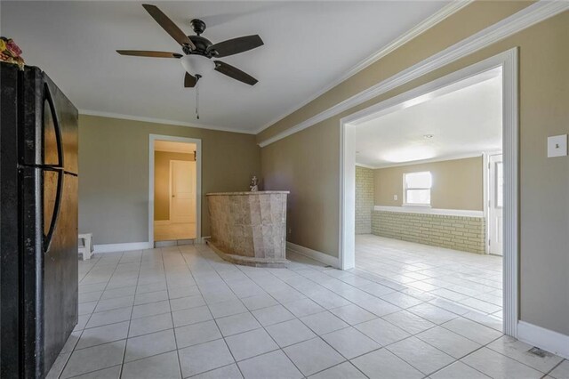 interior space with brick wall, ceiling fan, ornamental molding, and light tile patterned floors