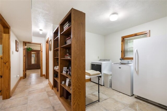 interior space featuring a textured ceiling, washer and dryer, and light tile patterned floors