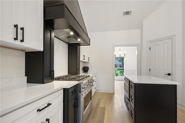 kitchen featuring a center island, white cabinetry, stainless steel appliances, and premium range hood