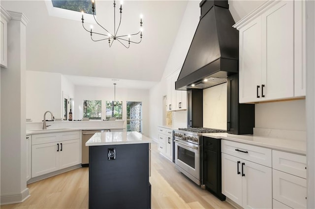 kitchen featuring custom exhaust hood, light countertops, appliances with stainless steel finishes, a chandelier, and a center island