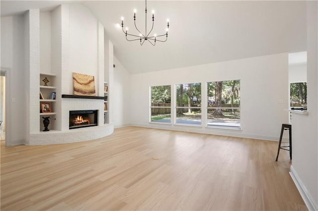 unfurnished living room with a brick fireplace, high vaulted ceiling, light wood-type flooring, and baseboards