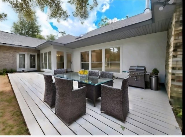 wooden terrace with area for grilling and outdoor dining space