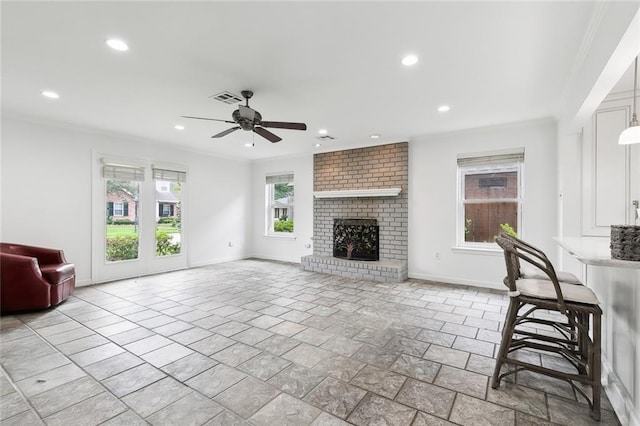 living room featuring ceiling fan, crown molding, and a fireplace