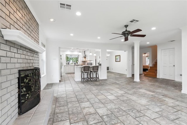 unfurnished living room with a fireplace and ceiling fan