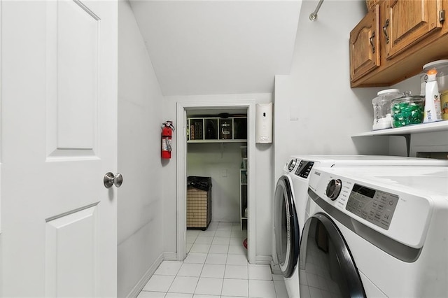 laundry area featuring cabinets, washing machine and dryer, and light tile patterned floors