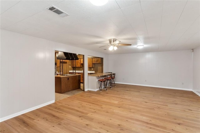 unfurnished living room featuring ceiling fan and light hardwood / wood-style floors