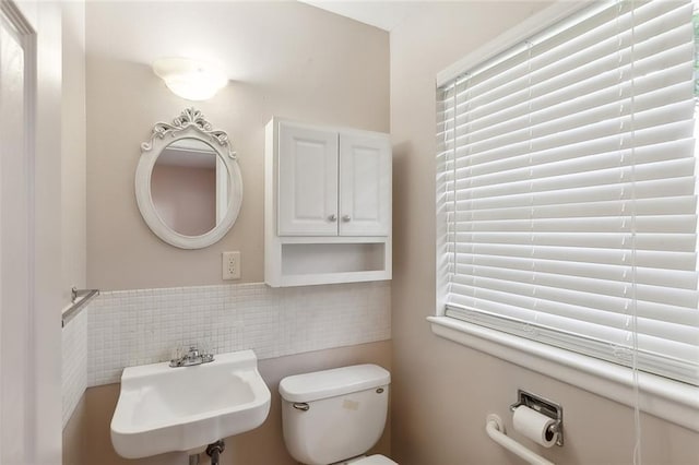 bathroom featuring a healthy amount of sunlight, sink, and toilet