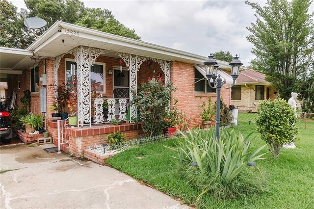 view of front of property featuring covered porch and a front yard