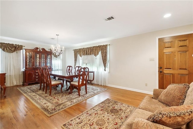 dining space featuring an inviting chandelier and hardwood / wood-style flooring