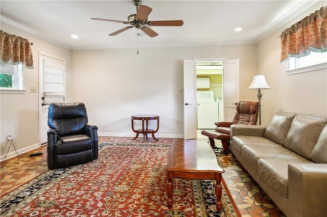 living room featuring ceiling fan, washer and clothes dryer, and crown molding