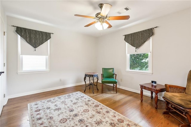 sitting room featuring ceiling fan, a wealth of natural light, and hardwood / wood-style floors