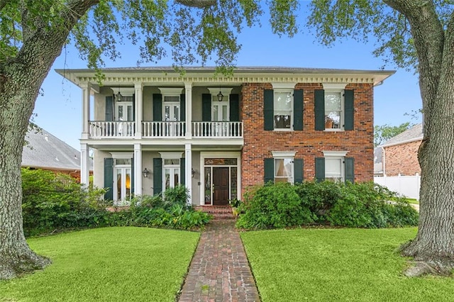 view of front facade featuring a balcony and a front yard