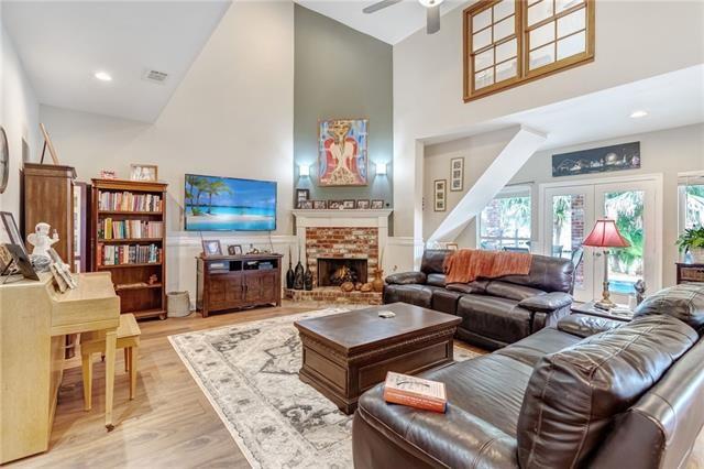 living room with high vaulted ceiling, ceiling fan, light hardwood / wood-style floors, and a fireplace