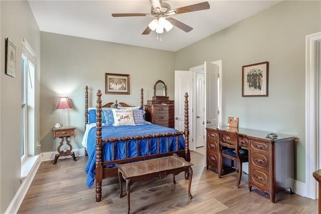 bedroom with ceiling fan, multiple windows, and hardwood / wood-style floors