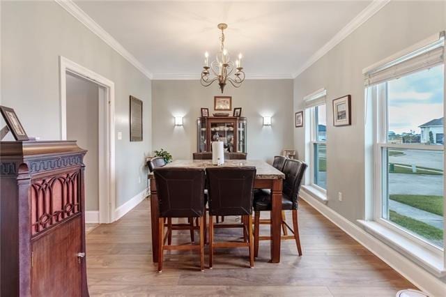 dining room with a notable chandelier, wood-type flooring, and ornamental molding