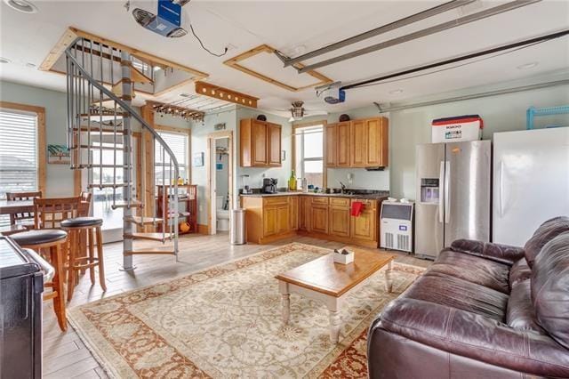 living room with ceiling fan, light hardwood / wood-style flooring, a wealth of natural light, and sink