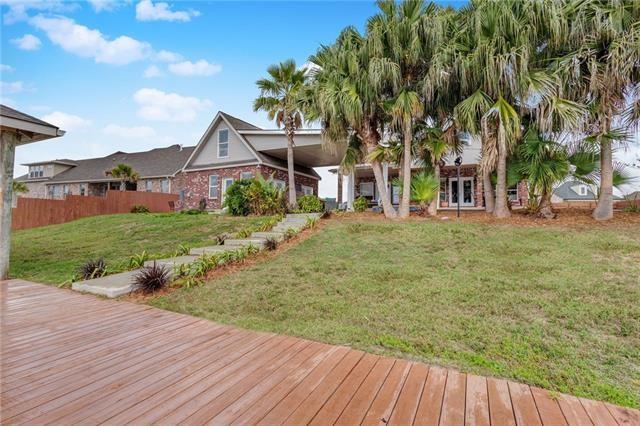 wooden terrace featuring a lawn