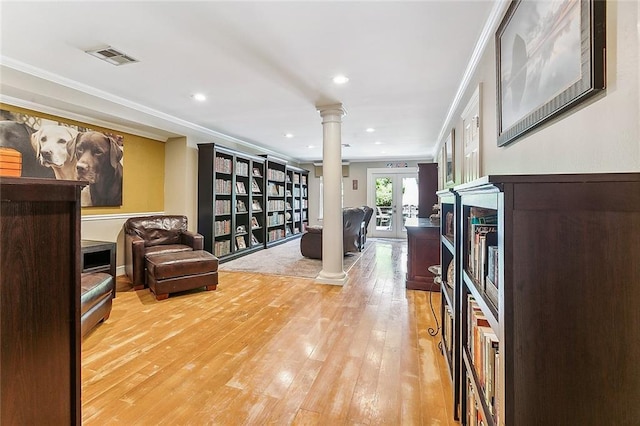 interior space featuring hardwood / wood-style flooring, decorative columns, crown molding, and french doors