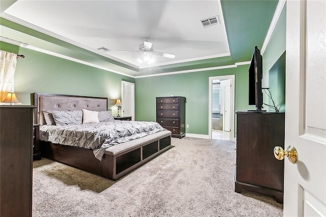 carpeted bedroom featuring ceiling fan, a raised ceiling, and connected bathroom