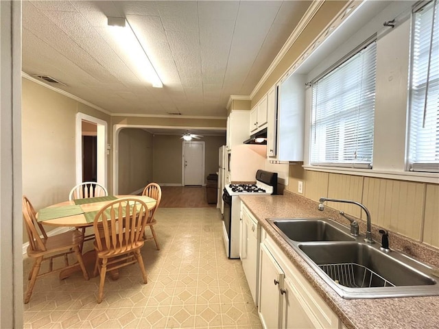 651 Avenue E Ave E, Westwego, LA 70094 - kitchen featuring gas range gas stove, crown molding, white cabinets, under cabinet range hood, and ceiling fan