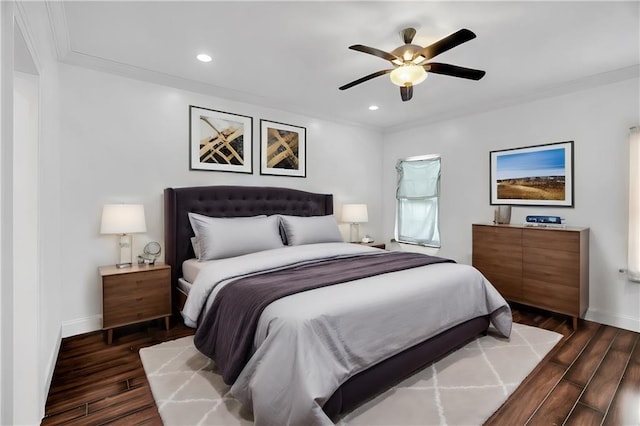 bedroom with crown molding, dark hardwood / wood-style flooring, and ceiling fan