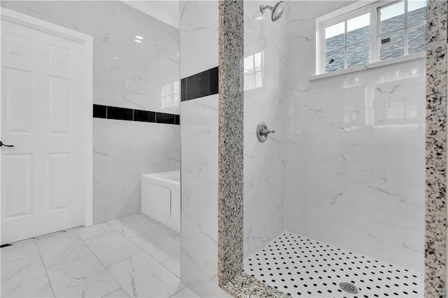 bathroom featuring tiled shower, tile patterned flooring, and tile walls