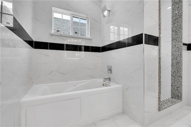 bathroom with independent shower and bath, tile patterned flooring, and tile walls