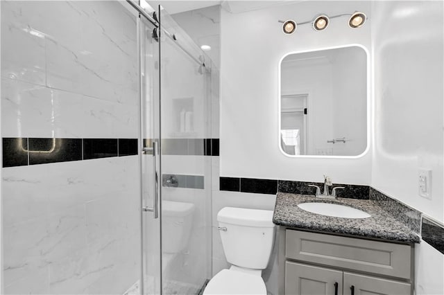 bathroom with vanity, toilet, walk in shower, and tile walls