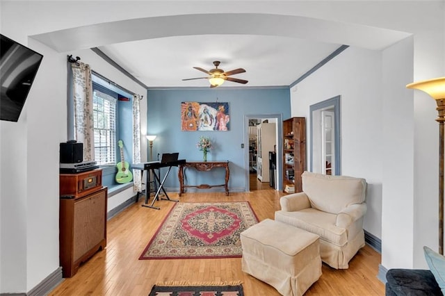 sitting room featuring crown molding, ceiling fan, and light wood-type flooring