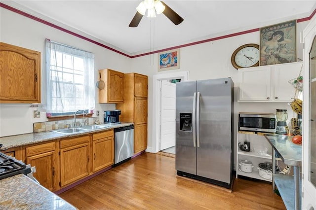 kitchen featuring ceiling fan, appliances with stainless steel finishes, sink, and light hardwood / wood-style floors