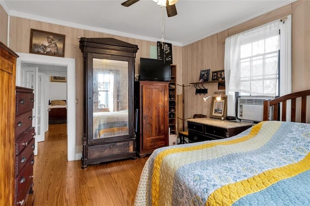 bedroom featuring multiple windows, cooling unit, crown molding, and hardwood / wood-style flooring