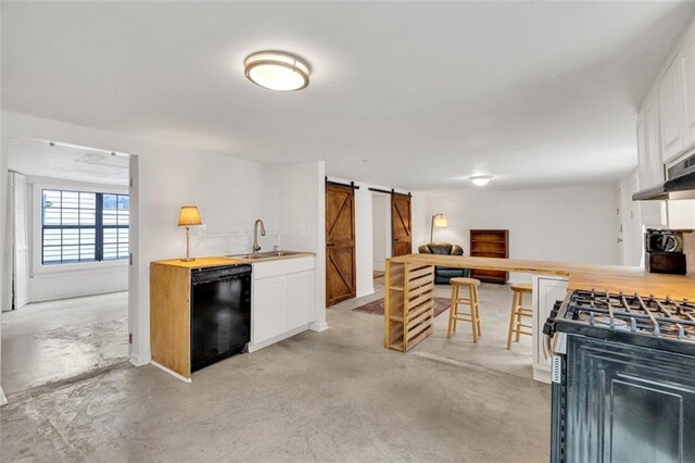 kitchen featuring sink, stainless steel gas range, dishwasher, white cabinetry, and a barn door