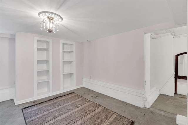 interior space featuring built in features and a chandelier