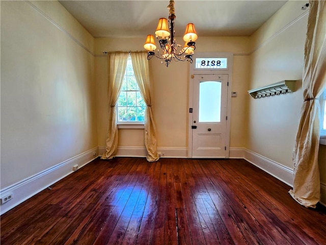 foyer with dark hardwood / wood-style floors and an inviting chandelier