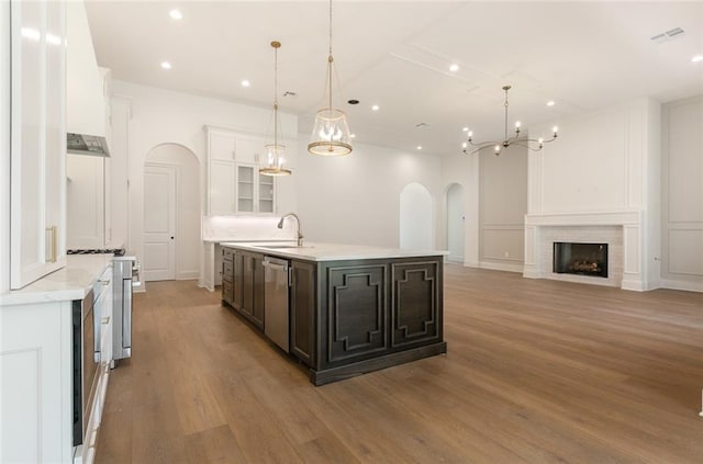 kitchen featuring hanging light fixtures, white cabinets, stainless steel appliances, and light hardwood / wood-style flooring