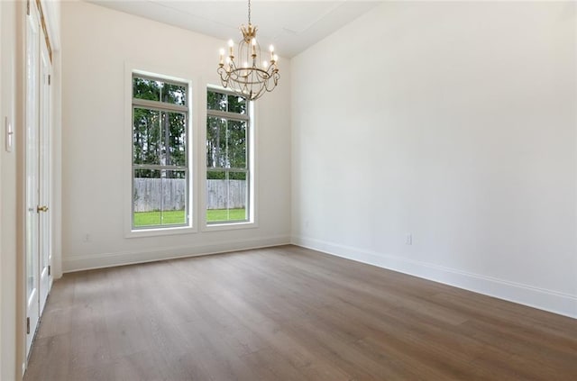 unfurnished room featuring wood-type flooring and a chandelier