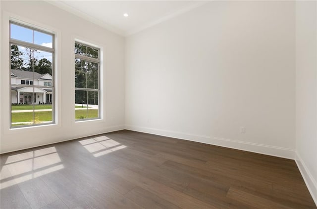 empty room with ornamental molding, plenty of natural light, and dark hardwood / wood-style floors