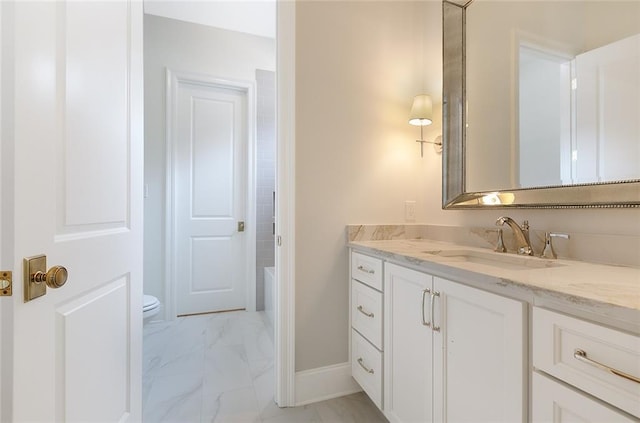 bathroom with vanity, a bathtub, and toilet