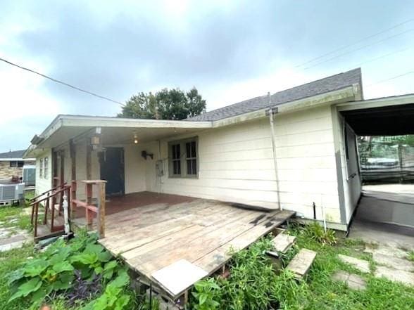 back of house with a deck and central air condition unit