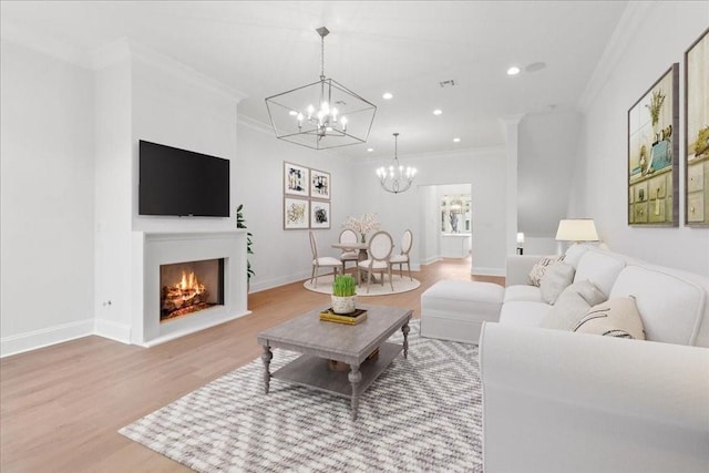 living room featuring a notable chandelier, crown molding, and wood-type flooring