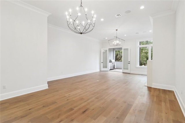 unfurnished living room with a chandelier, crown molding, and hardwood / wood-style floors